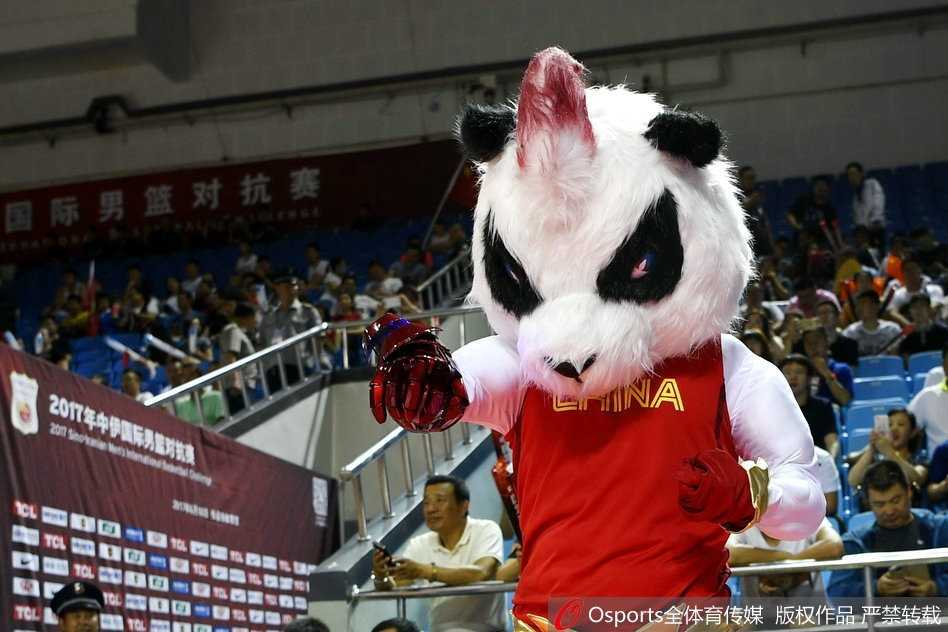 吉祥物做出搞怪的庆祝动作，双手抱头假装惊讶，逗得前排的小球迷开怀大笑。