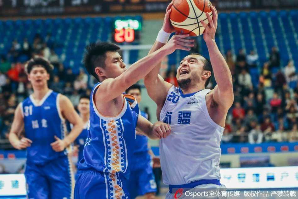西热力江面对防守人，眼神坚毅，强行干拔三分出手，展现新疆队长的大心脏本色。