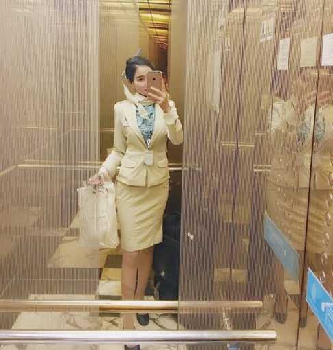 海风猛烈地吹起一位空姐的长发和长裙裙摆，她用手轻轻按住草帽，身体微微前倾，仿佛在与风嬉戏，动感十足的画面充满生命力。