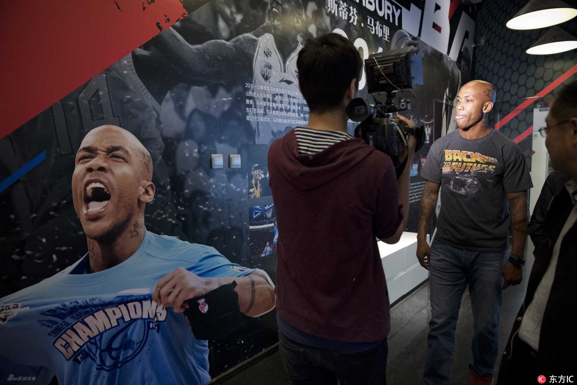 在个人博物馆内，马布里神情专注地听取记者提问，背景中那些属于他的荣耀时刻，见证了他袒露心声的全过程。