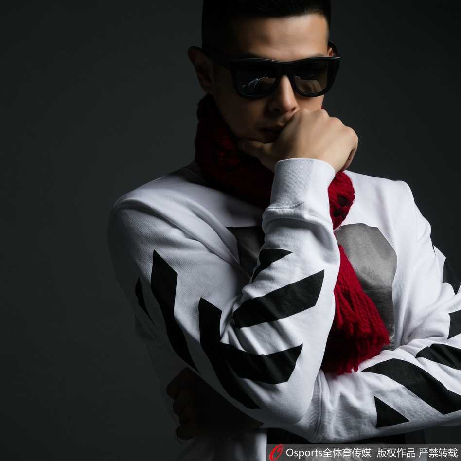 方硕正面坐姿照，身穿质感细腻的黑色毛衣，面带微笑，阳光洒在脸上，亲和力十足。