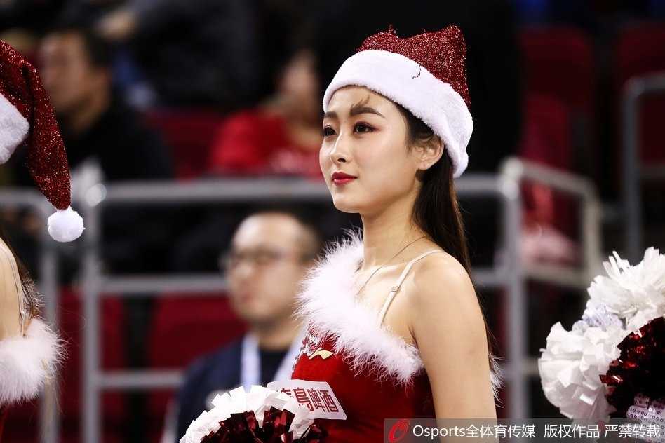 手挽着手，心连着心，篮球宝贝们迈着轻盈的步伐登场，她们身上的圣诞元素与手中的金色花球相映成趣，用最具感染力的笑容驱散了赛场的硝烟。