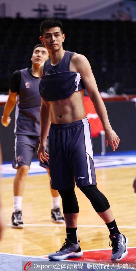 后场发动机方硕正在拉伸腿部韧带，进行赛前的最后准备，他紧致的腿部肌肉线条在灯光下清晰可见，展现了职业球员的身体素质。