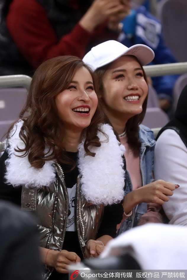 条纹衫女球迷在确认球队获胜后，绽放出阳光般灿烂的笑容，双手轻轻拢在身前，喜悦之情溢于言表。