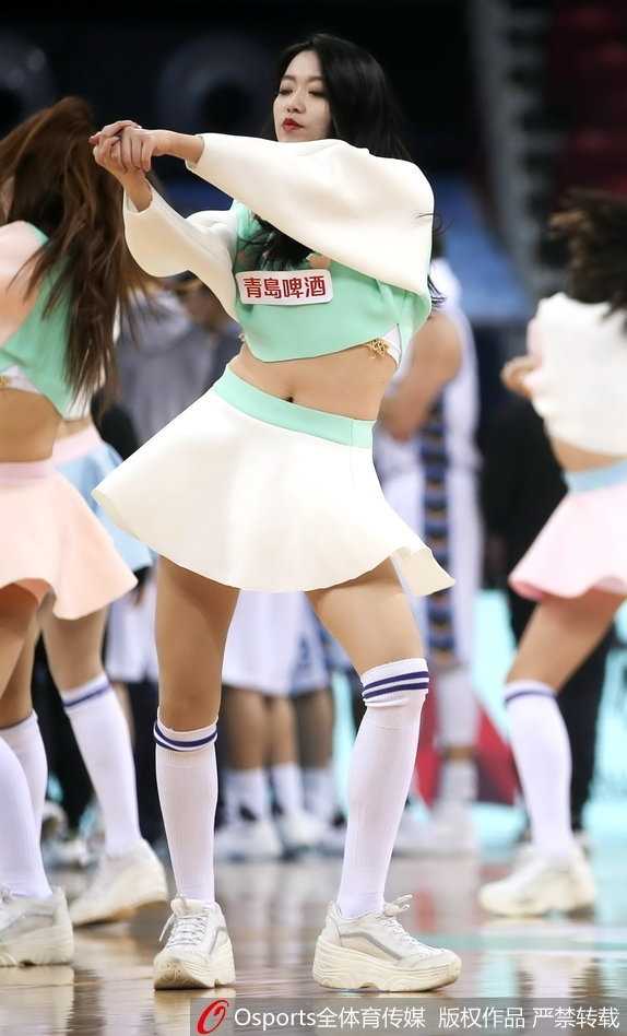 在蓝色的赛场地板映衬下，一名篮球宝贝正在忘情热舞，飞扬的发丝和自信的姿态，彰显着现代女性的活力之美，完美诠释了‘宝贝’二字的深刻内涵。