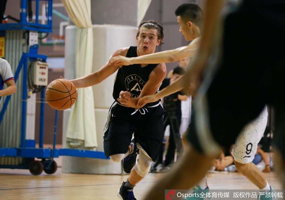 跳球瞬间，北京四中的高个球员奋力跃起，指尖几乎触碰到球皮，对面美国联队的球员则绷紧肌肉，空中形成一幅力量与高度对抗的剪影。