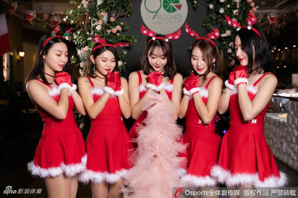 京城篮球宝贝的圣诞魔法:北控啦啦队节日温情瞬间 两位身着圣诞装的啦啦队员在摆满礼物的桌子后亲密合影,她们不仅准备了实用的帽子等小礼品,更用青春洋溢的笑容感染着过往的每一位球迷,现场充满了欢声笑语。