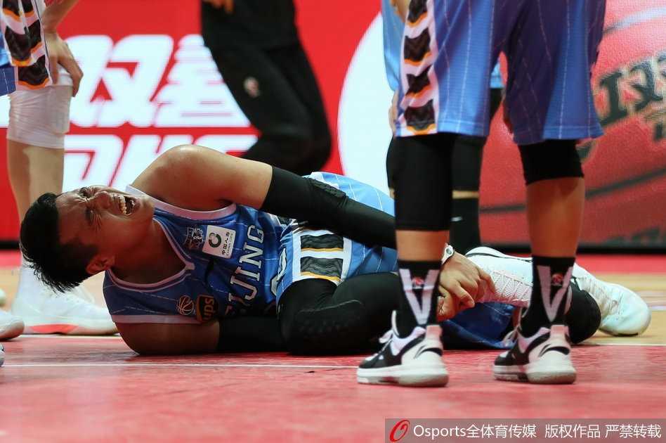 北京首钢球员在八一队的严密防守下强行突破，身体在空中完全舒展，眼神里透着必胜的决心。