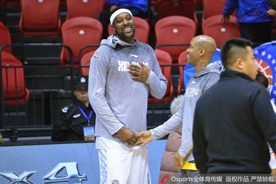 布拉切微微低头，认真倾听马布里说话，马布里则比划着手势，似乎在分享什么赛场心得，旁边的队友也在驻足观看。