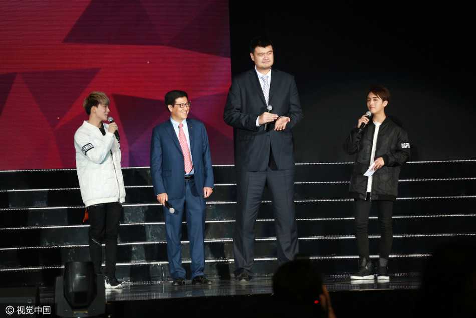 身着一袭深色西装的姚明，在舞台侧幕静静注视着台上的表演，背景的灯光虚化成流光溢彩的光晕，仿佛在沉思着跨界而来的别样体验。