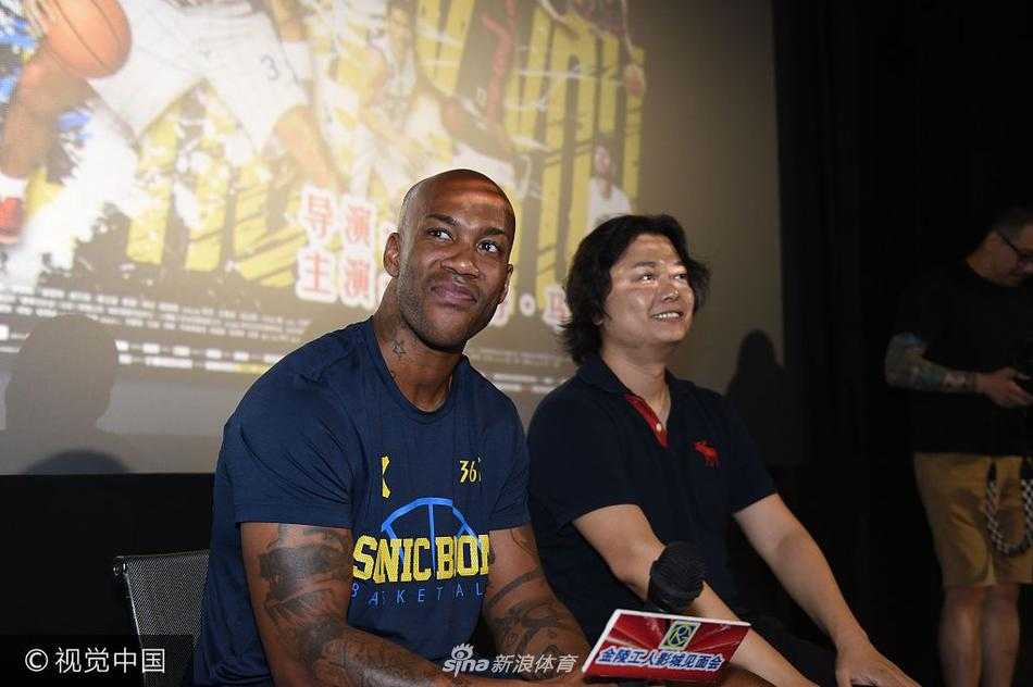 导演杨子和马布里并肩而立，正在接受媒体群访。杨子手持话筒认真倾听，马布里则侧身看向导演，两人神情专注，展现出合作无间的默契。