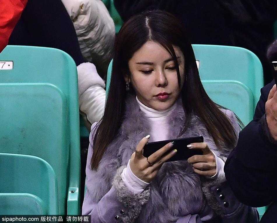 中场休息的闲暇时光，这位留着柔顺长发的女孩对着镜头露出了明媚如阳光般的灿烂微笑，手中挥舞着助威棒。那份发自内心的快乐，仿佛能感染整个球馆，让人忘却比赛的紧张，只沉醉于篮球带来的纯粹喜悦。