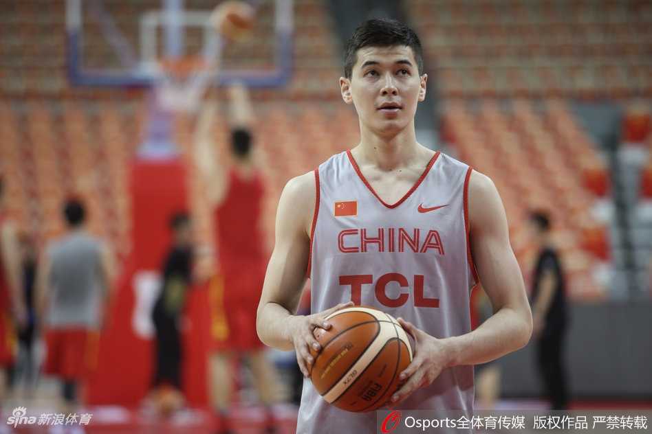 主教练李楠双手环抱于胸前，神情专注地注视着场内训练，眼神中透露出对细节的严格要求和对球员成长的殷切期望。