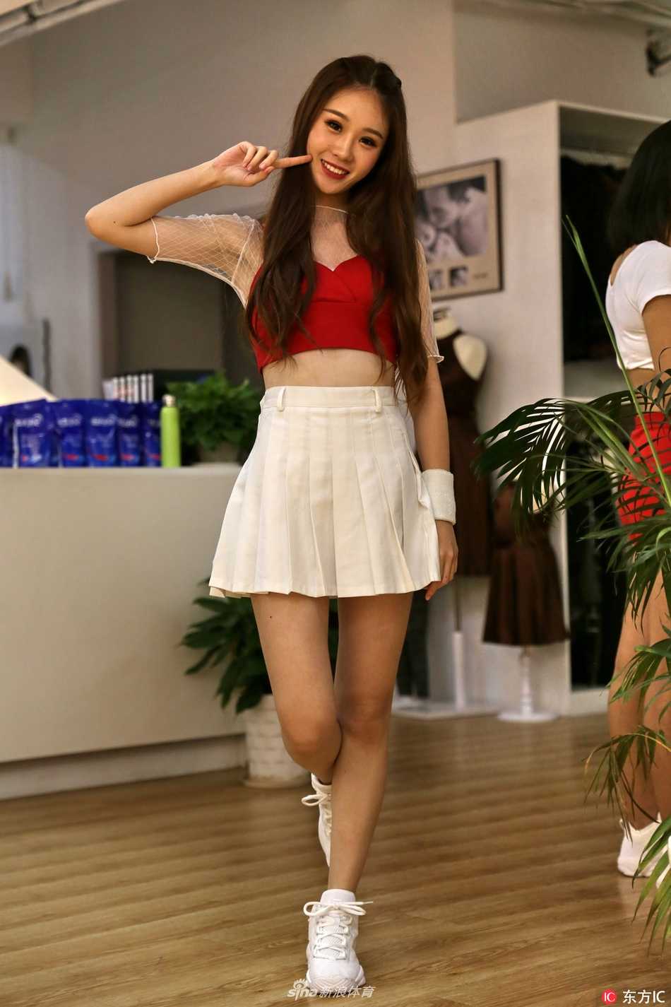 阳光透过树叶洒下斑驳的光影，篮球宝贝安静地倚靠在墙边，嘴角带着若有若无的笑意。简单的白T配短裙，却穿出了青春最动人的模样，清纯可爱得刚刚好。