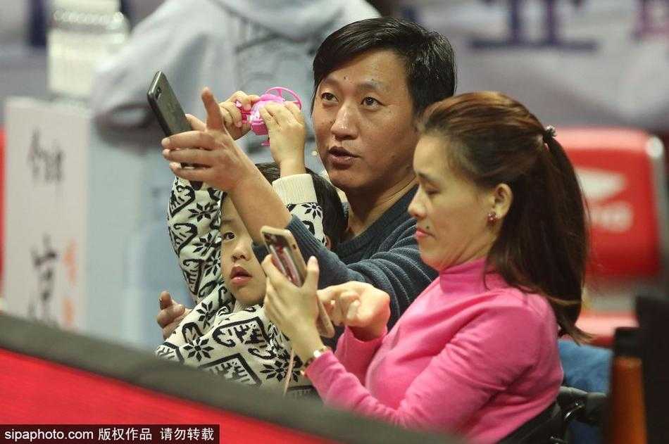 桑兰怀抱着儿子，一家三口在体育馆的背景板前留下合影，儿子天真烂漫的笑容成为这张照片中最亮眼的焦点。