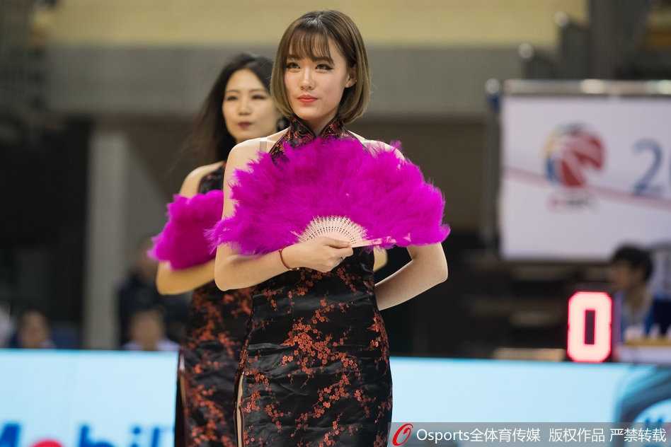 江苏肯帝亚啦啦队成员们身穿修身的淡雅印花旗袍，在高强度的篮球赛场边，手持粉红彩扇排成一列，身姿挺拔，宛如一幅流动的江南画卷。