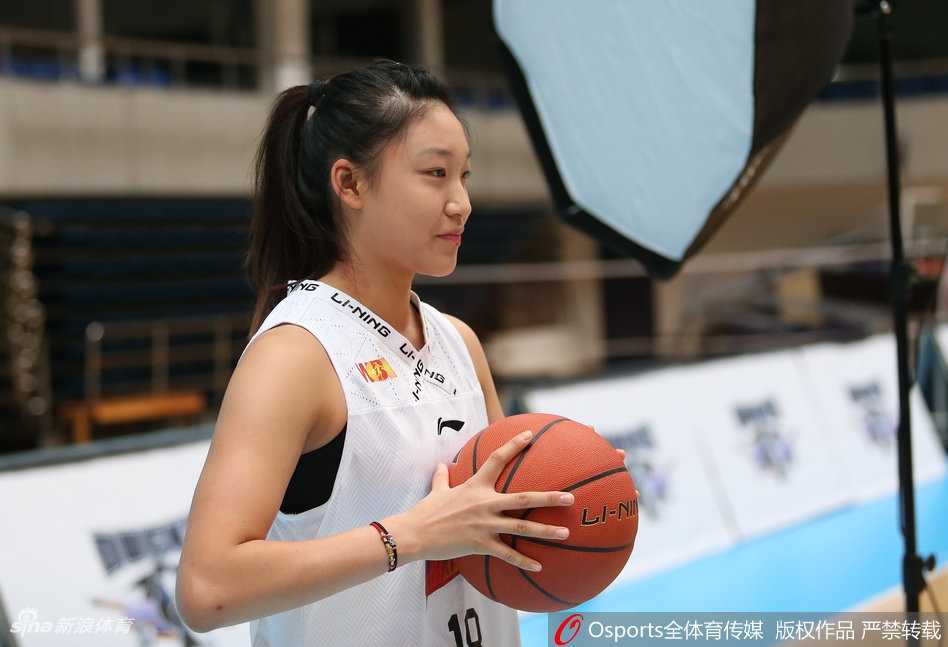 北京女篮双面风采:赛场铁血女王,镜头倾城女神 马尾辫显得干练十足,队员身着一袭黑色运动休闲装,双手插兜,眼神坚定地望向远方,背景的虚化处理让主体人物更加突出,宛如时尚大片封面。