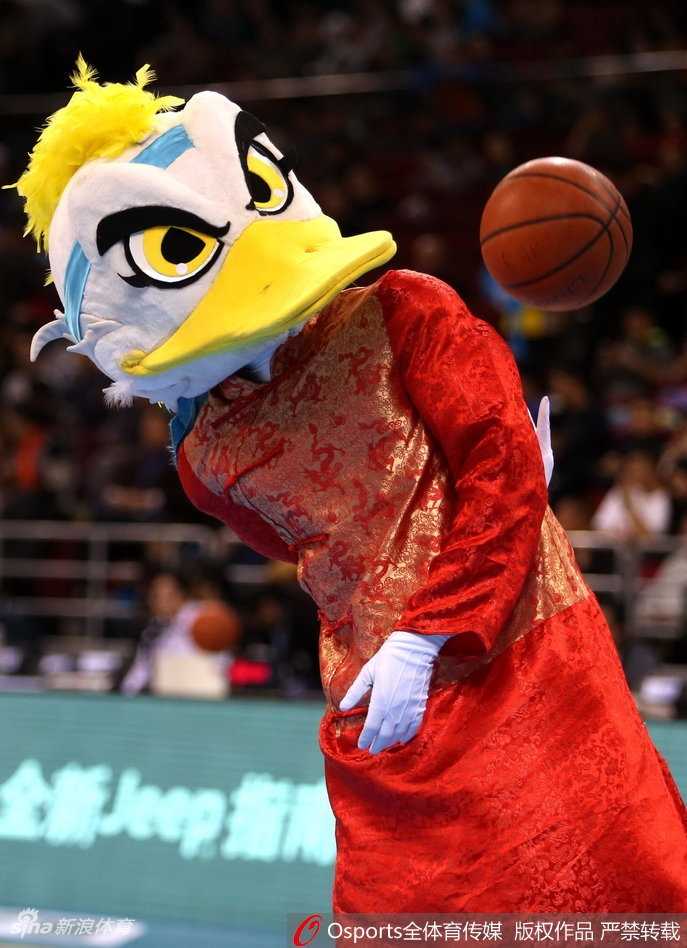 吉祥物霹雳鸭戴着传统的瓜皮小帽，穿着绣有福字的红马甲，双手叉腰站在罚球线后，正歪着头观察着场上正在罚球的四川队外援哈达迪。