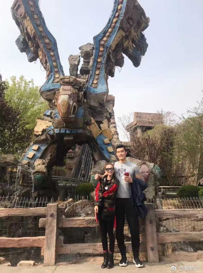 郭凯在球场上挥洒汗水的瞬间，身着北大红色战袍，眼神专注而坚定，肌肉线条分明，充满了力量感，与场下的温柔形成鲜明对比。