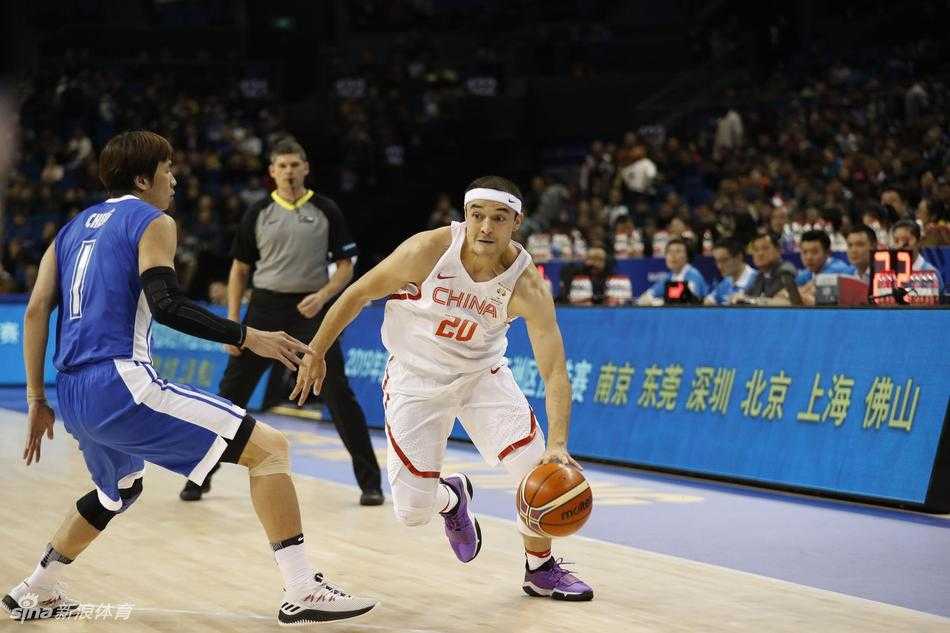 南京青奥园男篮大捷 红队狂胜香港启征程 赛后,主教练李楠在场边接受采访,表情严肃而专注,背景是兴奋庆祝胜利的队员们,这一幕凝聚了教练的运筹帷幄与球员的激情释放。