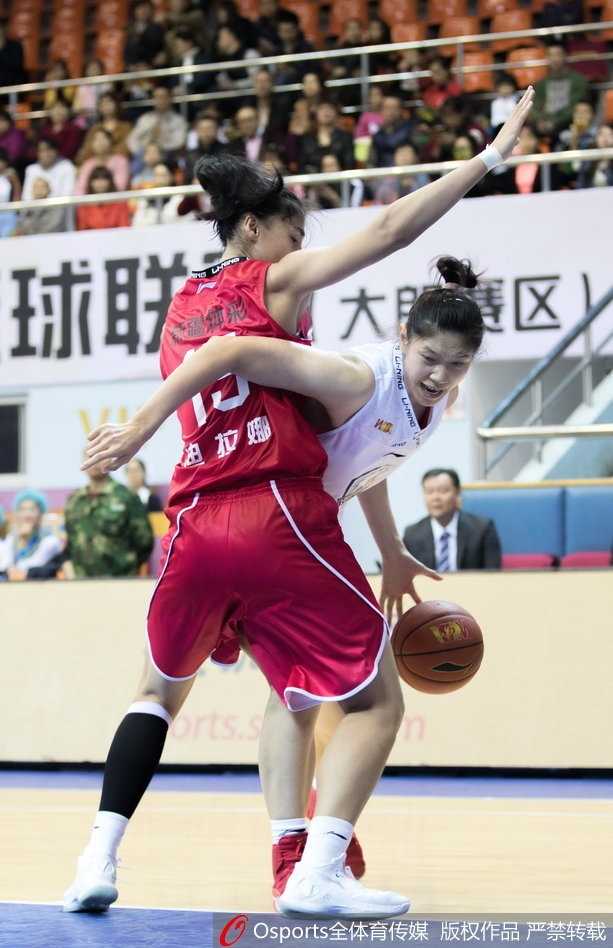 新疆球员迪拉娜在对抗中高高跃起，与广东队防守球员激烈拼抢篮板球。两人在空中形成错位，肌肉碰撞的声音仿佛穿透了画面。