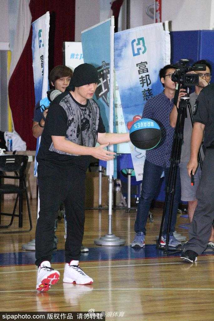 周杰伦裹头巾英姿飒爽现身球场 携富邦勇士为偏乡学童点燃篮球梦 周杰伦站在一架投影钢琴前,面带微笑地挥舞着手臂进行指挥,他身旁的富邦勇士队球星们正用手中的篮球精准地砸向琴键,共同演绎出听妈妈的话的旋律,场面既新奇又温馨。