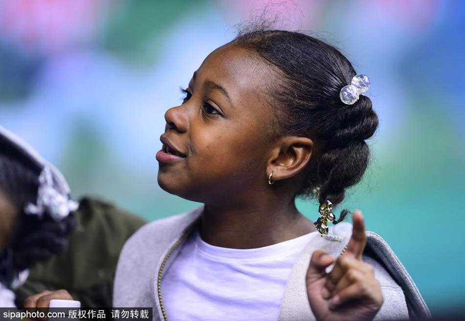 面对激烈的对抗，姐姐的表情略显紧张，双手紧紧攥在一起，仿佛在为爸爸的每一次持球进攻而揪心。