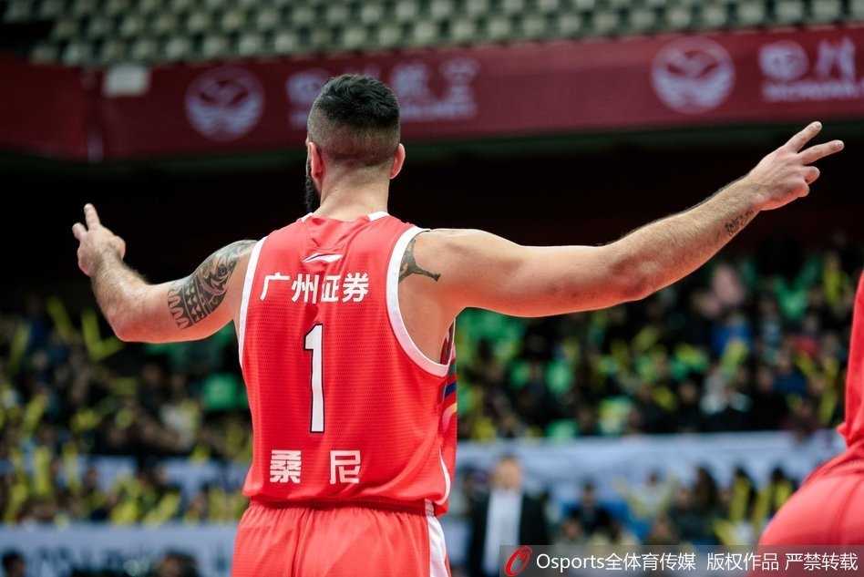 广州队球员胡珑贸在场上眼神坚定，他正准备将球传给位置更好的队友，体现了球队团队配合的战术素养。