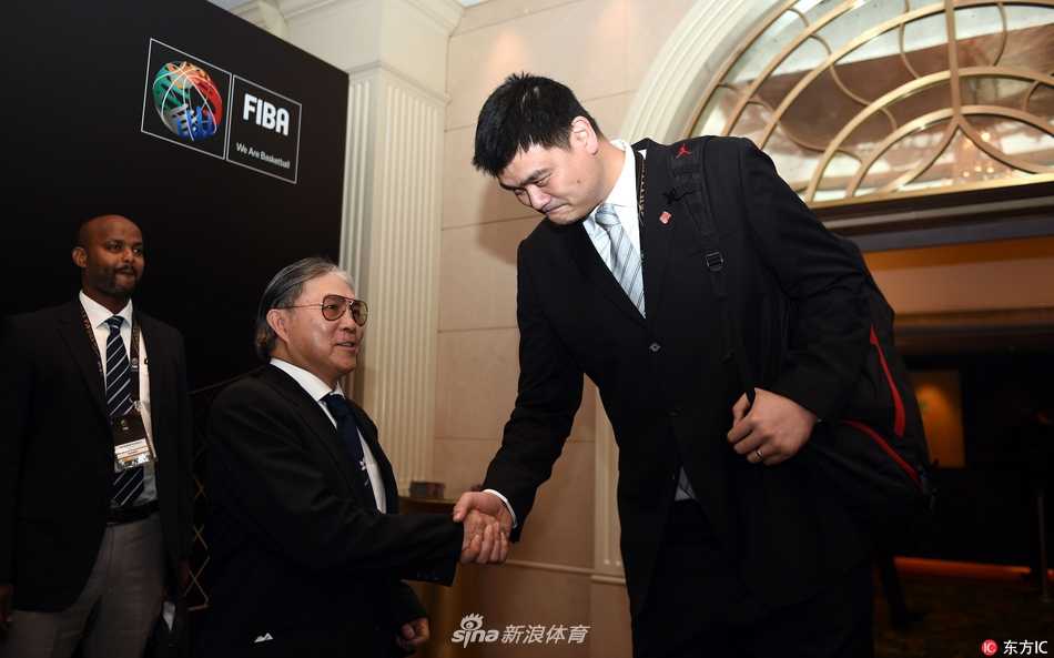 在庄重的会议主会场内，姚明侧耳倾听其他代表的发言，他面前的桌牌清晰地标注着中国，显示出他作为中国篮球掌舵人参与国际事务的专注与投入