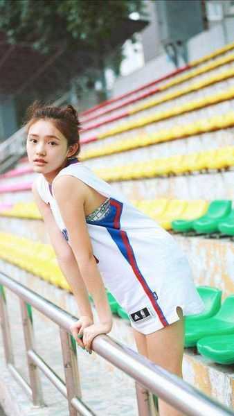 夏日球场甜心:女生篮球背心穿搭图鉴,解锁元气运动风 少女轻倚沙发,一袭经典红色篮球背心宽松地罩在身上,背后是温柔的暖黄灯光,眼神坚定又带着一丝慵懒,宛如漫画中走出的运动系女主角。