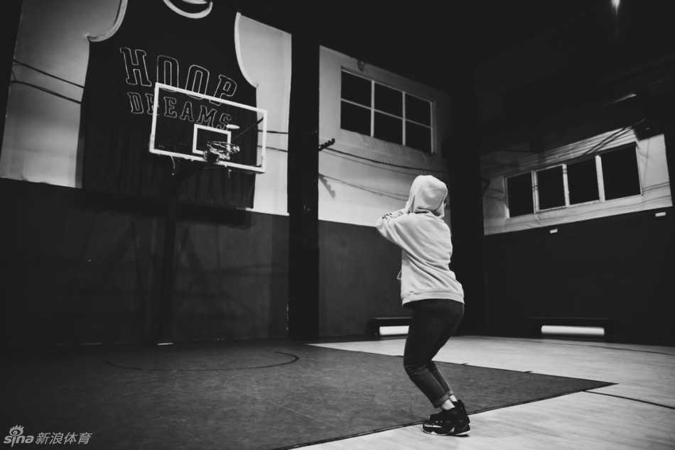 夕阳下的扣篮梦:一位詹姆斯小迷妹的篮球征程 女孩在空中奋力一跃,身体舒展到极致,手中的篮球高高举起,正努力向着篮筐的方向送去。夕阳在她身后形成一道剪影,画面充满动感与力量。