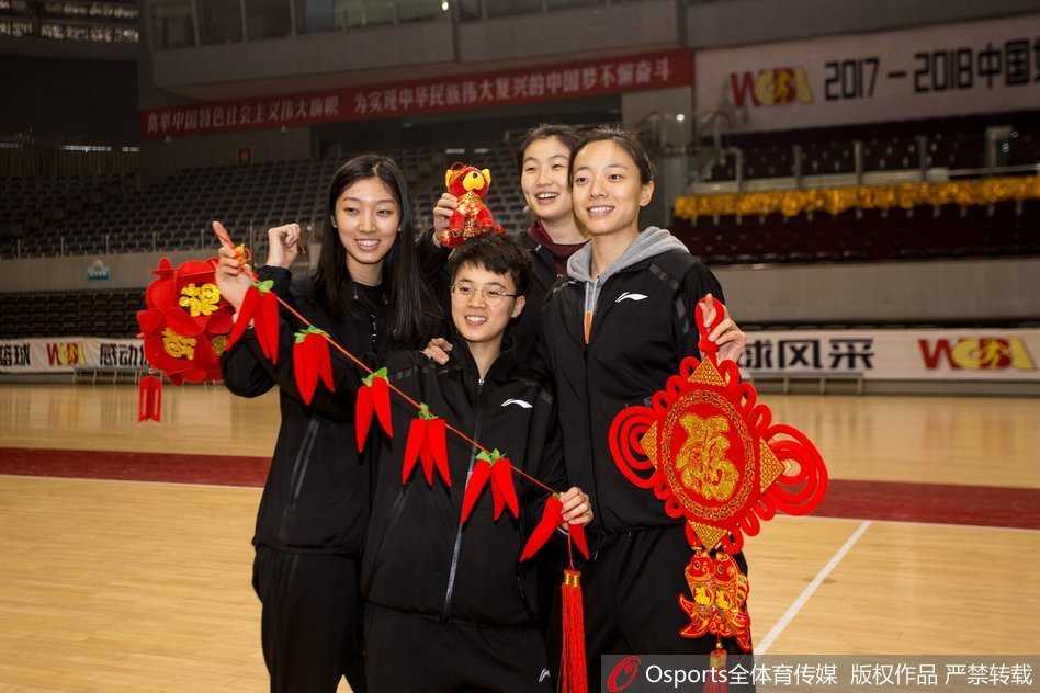 天山玫瑰送新春:新疆女篮的年味与查尔斯的眷恋 队员们对着镜头比出“耶”的手势,有人拿着春联,有人拿着福字,背景中红色与金色的装饰交织,整个画面洋溢着青春与活力的气息。