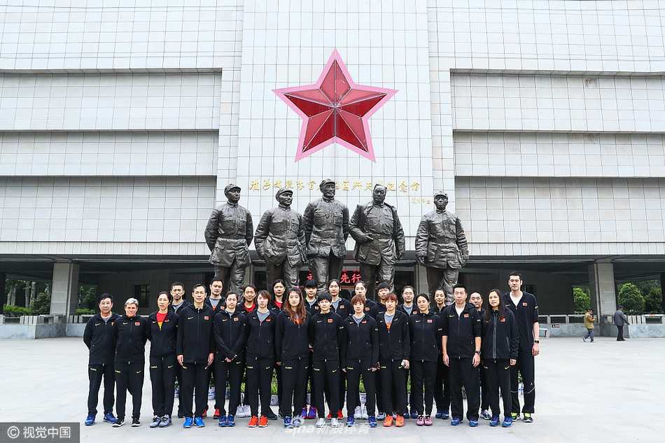 女篮队员们身着整齐的队服，在淮海战役纪念馆的大型浮雕前驻足仰望，神情庄重而专注，仿佛正与历史进行着一场无声的对话。