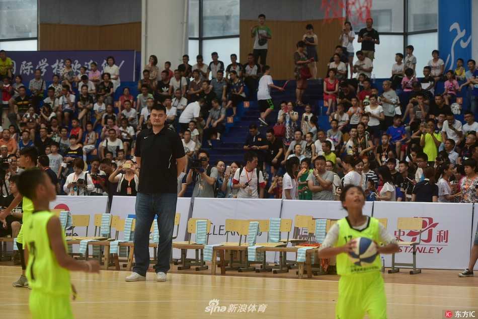 活动结束后，姚明被一群身穿红色球衣的小球员团团围住，大家簇拥着这位篮球巨人合影留念，孩子们兴奋地做出投篮姿势，姚明则面带微笑，温柔地看着镜头