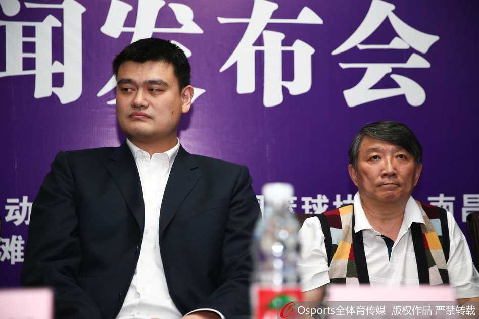 姚明在发布会现场独坐一隅，虽然身居高位，但眉宇间透露出对中国篮球现状的深思，背景虚化的灯光映衬出他肩负的改革重任与无数球迷的期待。