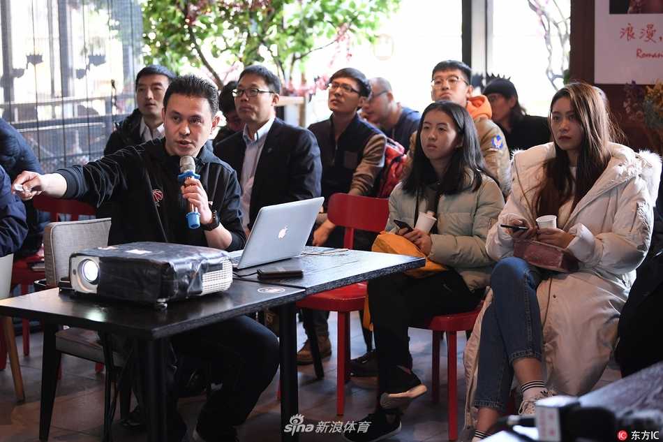 媒体之家活动全景，长桌旁围坐着数十位媒体记者和工作人员，背景屏幕上显示着CBA联赛的标志，气氛轻松而专注。