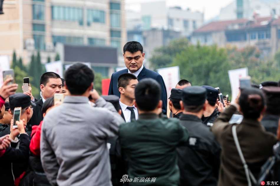 课堂上，姚明正拿着一个写有“酒精知识教育读本”的册子，他身后的黑板上用彩色粉笔画着象征健康和禁止饮酒的图案，整个教室充满了活泼的学习氛围。