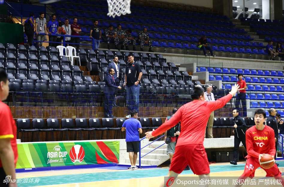 姚明端坐于看台之上，眼神中透露出对赛况的关切与深思，仿佛在脑海中快速拆解着场上每一个战术细节。