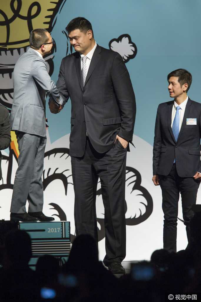 论坛讲台上，姚明手持话筒侃侃而谈，身后的巨大屏幕映出论坛主题字样。李泽楷身着修身西装坐在一旁，双手交叉认真聆听，两人同框的视觉反差萌翻了全场。