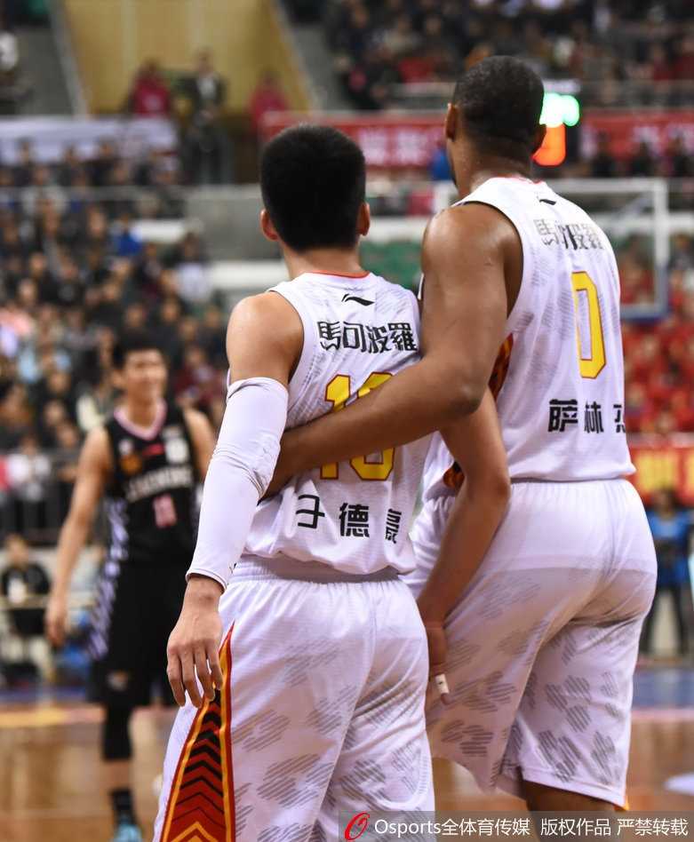 于德豪在人群中高高跃起，拼抢下关键的篮板球，他的眼神坚定，肌肉紧绷，展现出与郭艾伦对抗时的强硬姿态。