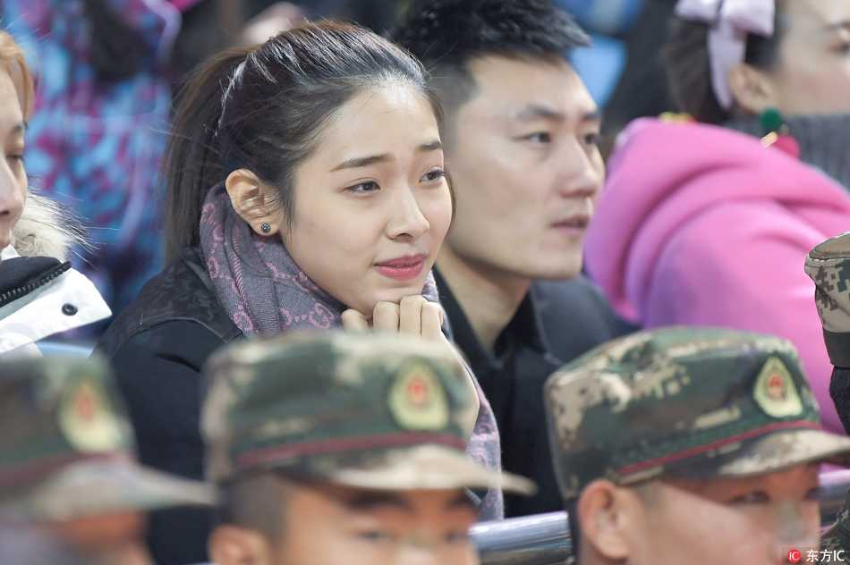 一位身着黑色卫衣的年轻女球迷，双手轻轻托腮，眼神专注地望向赛场，仿佛东北虎的每一次进攻都牵动着她的心弦。