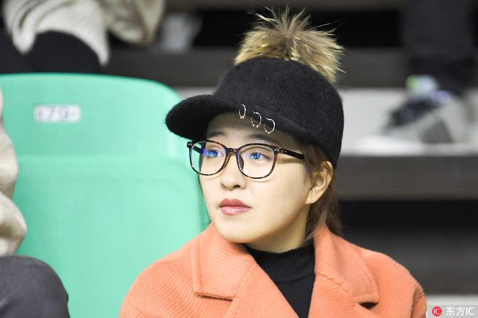 赛后，一位笑靥如花的女球迷举起手中的围巾向赛场挥舞，眼神中充满了对主队获胜的自豪与喜悦。