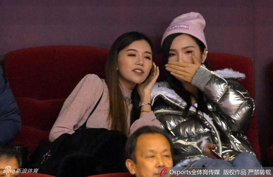 山东男篮太太团助阵,丁彦雨航女友与睢冉妻子看台斗艳 睢冉妻子举起手机对着场内拍照,想要捕捉丈夫在替补席的画面,一旁的丁彦雨航女友也侧身探头,两人共同关注着山东队的每一次攻防。