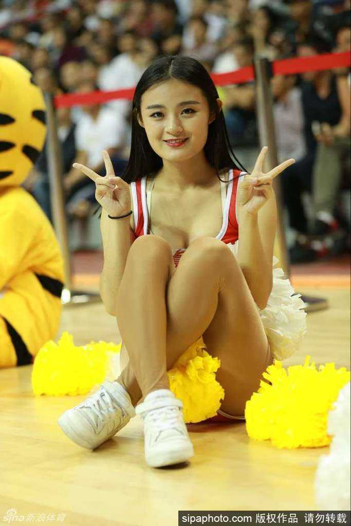 新疆队的拉拉宝贝们在场地中央排开整齐的队形，她们手中挥舞着金色的花球，动作整齐划一，充满了力量感，将红山体育馆的主场氛围推向新的高潮。