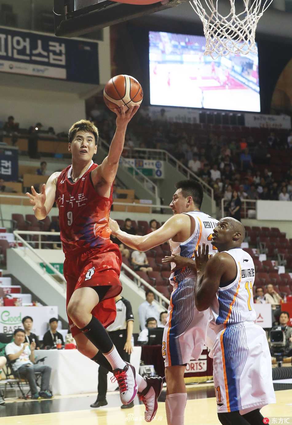 老将刘炜在比赛中持球组织进攻，他面对韩国后卫的贴身紧防，眼神坚定，利用丰富的经验为队友创造得分机会