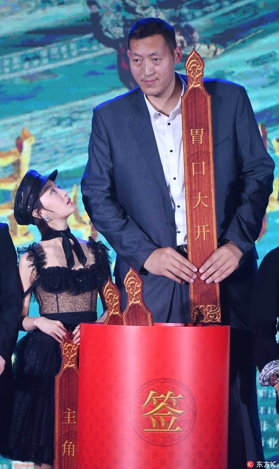 孙明明在签名板前驻足留影，身着简约服饰却难掩磅礴气势，镜头仰视之下更显其巍峨，一举一动都散发着从体育健将到银幕新星的从容转变。