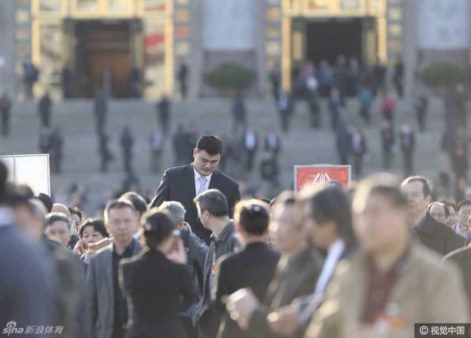 巨人身影后的五年履职路 姚明两会留下深刻足迹 会场外的台阶上,姚明被几位与会者围绕,他们正热切地交谈,姚明微微倾身配合对方,尽显平易近人的风度