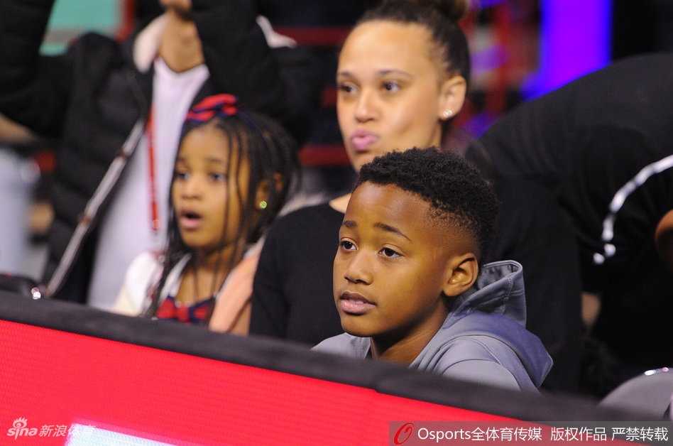 巴斯与儿子温馨互动，小家伙眼神中似乎透着对父亲英雄形象的崇拜，这一刻的温情与刚刚球场的硝烟形成鲜明对比。