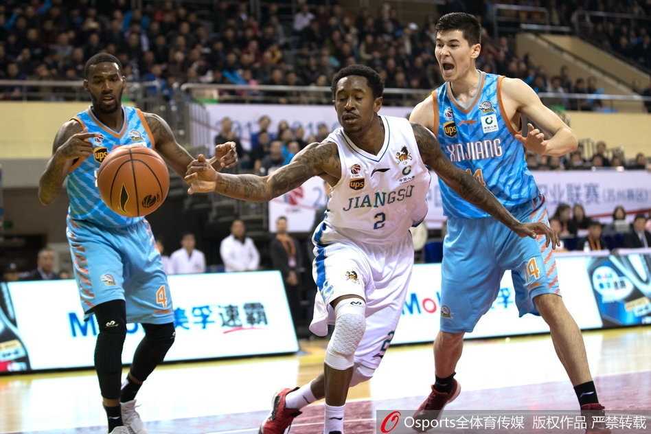 江苏肯帝亚主教练贝西诺维奇在暂停期间，手持战术板，神情专注地向球员们布置战术，队员们围成一圈认真聆听，体现了球队良好的团队氛围。