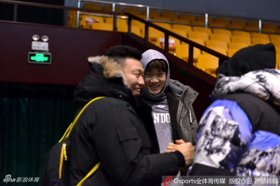 身披帽衫的丁彦雨航在训练场边若有所思，眼神中透露着对胜利的渴望与坚定。